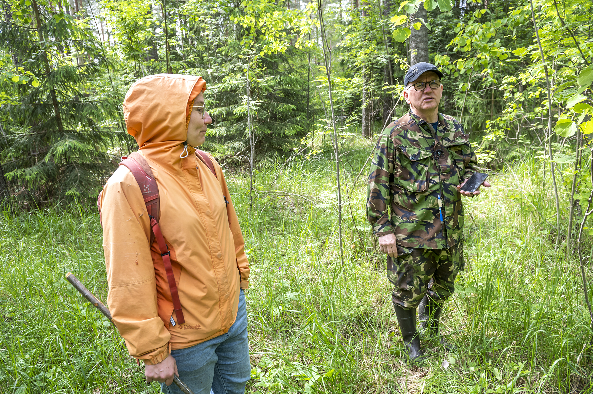 kaksi henkilöä keskustelee talousmetsässä