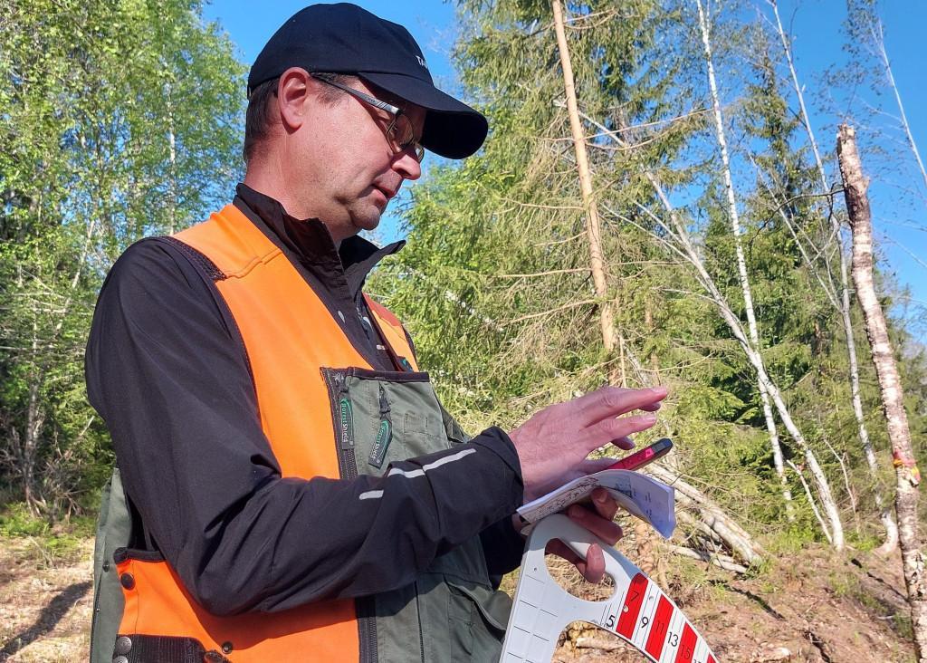 Tapio Palvelut Oy:n metsätalouden kestävyysasiantuntija Tommi Tenhola kirjaa havaintojaan laadunarviointikohteella.