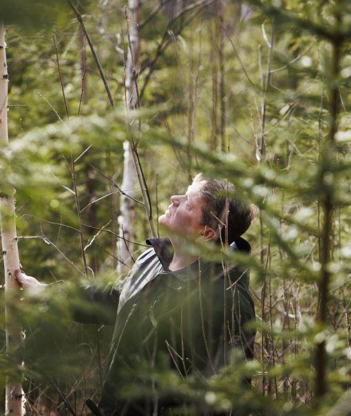 metsänomistaja tarkastelee metsikköä