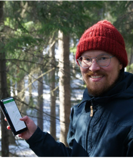 Petri Latva-Käyrä puhelin kädessään talvisessa metsässä